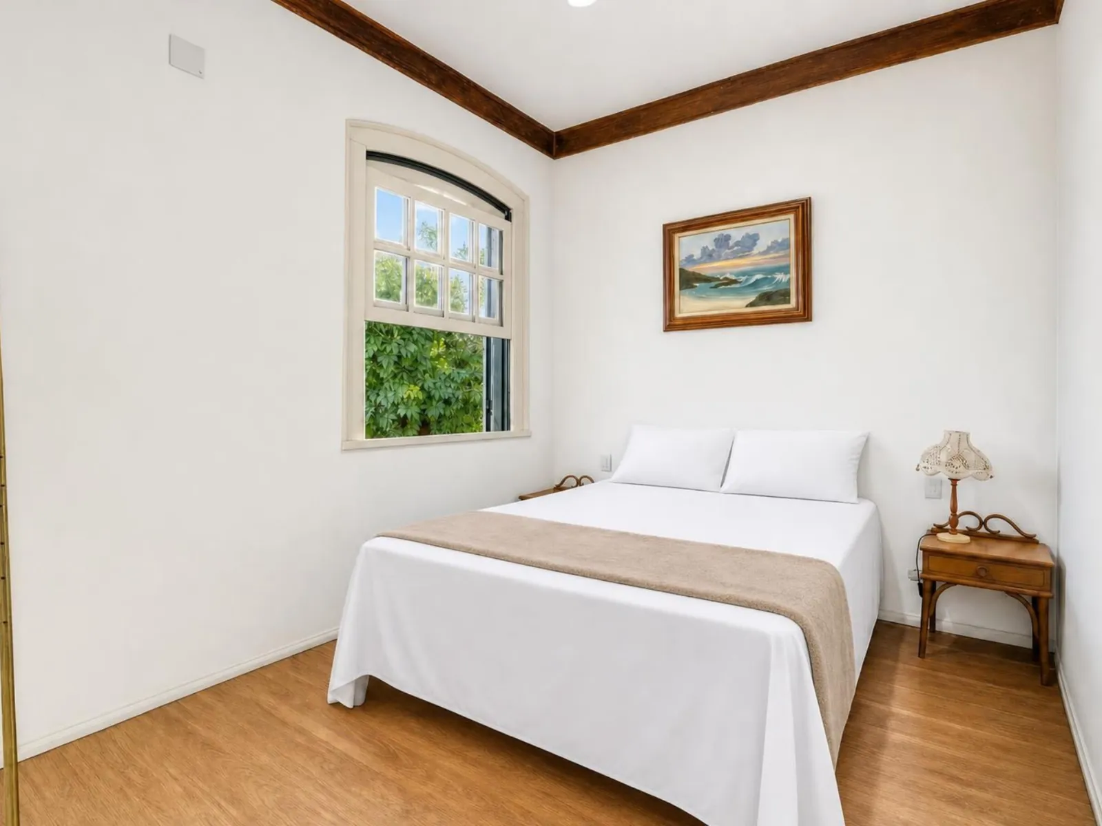 Suíte 1 da Casa Mares, com cama de casal e janela para o jardim