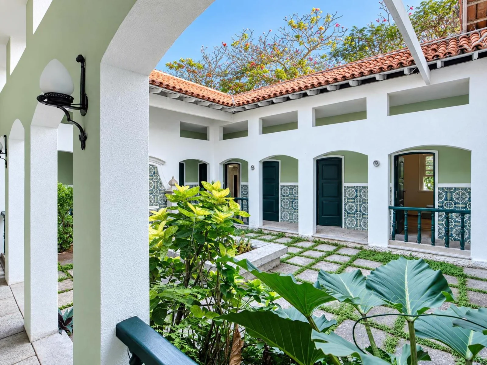 Pátio interno com arcos, azulejos e plantas